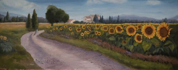 A pathway running through a field of sunflowers with a distant farmhouse and trees.