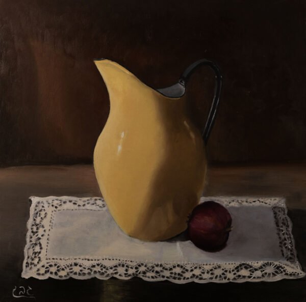 A yellow ceramic pitcher next to a red onion on a lace tablecloth.
